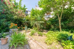 a garden with plants and trees and a building at Diana's Chamber in Pula