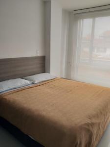 a large bed in a bedroom with a window at Embassy On Holidays in Bogotá