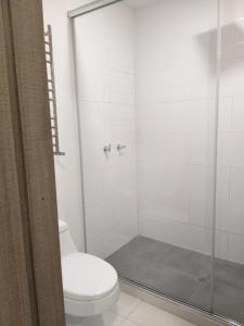 a bathroom with a toilet and a glass shower at Embassy On Holidays in Bogotá