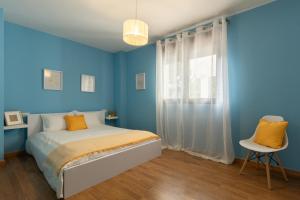 a blue bedroom with a bed and a window at Casa Clara in Isla de Arosa