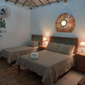 a bedroom with two beds and a clock on the wall at Pousada Campestre Vila Tiradentes in Tiradentes +113 photos
