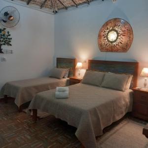 una camera da letto con due letti e un orologio a parete di Pousada Campestre Vila Tiradentes a Tiradentes