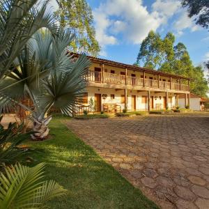 a large building with a porch and a courtyard at Pousada Campestre Vila Tiradentes in Tiradentes