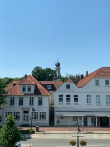 een groep gebouwen met een vuurtoren op de achtergrond bij Schloss Blick Bredendiek in Jever