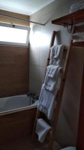 La salle de bains est pourvue d'une échelle de serviettes et d'une baignoire. dans l'établissement Quinta da Maria, à Horta