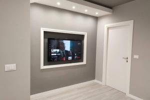 a flat screen tv on a wall in a room at Incantevole appartamento sul mare - Borgo Marina in Imperia