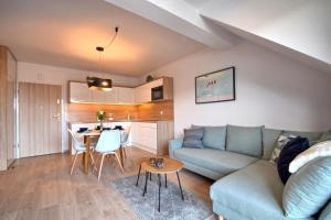 uma sala de estar com um sofá e uma mesa em Apartament z widokiem, osiedle FENIKS em Kolobrzeg