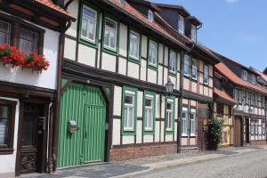 a row of houses with green doors on a street at Ferienwohnung Altstadtidylle 3 in Wernigerode