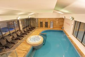 uma piscina num quarto de hotel com cadeiras em Apartament z widokiem, osiedle FENIKS em Kolobrzeg