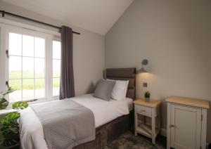 1 dormitorio con cama y ventana en The Kings Arms en Coggeshall
