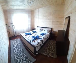 Bett in einem kleinen Zimmer mit Fenster in der Unterkunft Затишні Карпати)) in Werchowyna