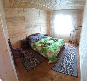 Cette petite chambre comprend un lit et une fenêtre. dans l'établissement Затишні Карпати)), à Verkhovyna