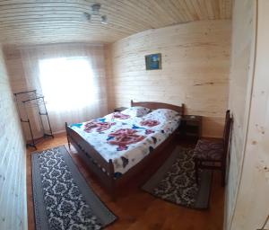 ein Schlafzimmer mit einem Bett in einer Holzhütte in der Unterkunft Затишні Карпати)) in Werchowyna