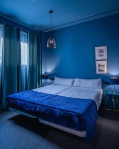 a bedroom with a blue and white bed and a blue wall at HoGraFic hotel boutique in Valencia