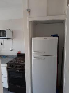 a small kitchen with a refrigerator and a stove at Monoambiente Puerto de Olivos in Olivos +2 photos