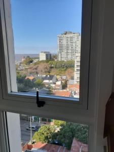 una ventana con un pájaro sentado en la cornisa en Monoambiente Puerto de Olivos in 