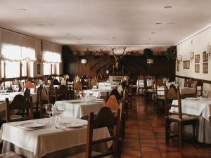 ein Restaurant mit Tischen und Stühlen mit weißen Tischdecken in der Unterkunft Hotel Rebeco in Fuente Dé