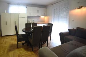 a living room with a table and chairs and a kitchen at Panoramske Vile in Vrnjačka Banja