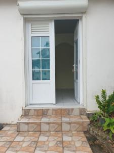 a white door on a house with a patio at Villa Rose & F in Sainte-Anne