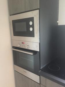 a microwave oven sitting on top of a wall at L'Ecume de Mer in Wissant +6 photos