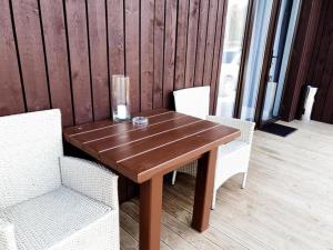 a wooden table with two chairs and a vase on it at Stonkų sodyba Grapeldvaris in Varkaliai