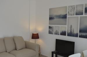 uma sala de estar com um sofá e uma televisão em Moradia V2 nova e próximo da praia em Vila Nova de Cacela