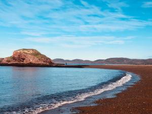a beach with a large rock in the water at The Southern Port Hotel & Chalets in Harbour Breton