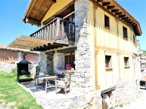 Casa de piedra con mesa y balcón en Casasdetrevijano Mirador de Mateo, en Soto en Cameros