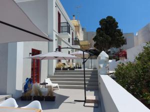 a patio with tables and umbrellas on a building at Ermoupolis hidden gems in Ermoupoli