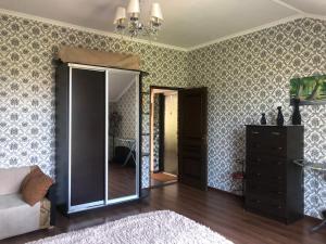 een woonkamer met een spiegel en een dressoir bij Pod evkaliptom Apartment in Gagra