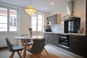 a kitchen with a table and chairs and a stove at Le Balcon de Colmar in Colmar