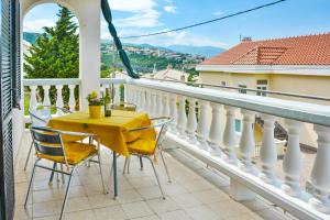 a balcony with a yellow table and chairs at Apartman Gabrijela in Senj