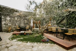 patio ze stołami i krzesłami przed ścianą w obiekcie Atelier Boutique Hotel w Szkodrze