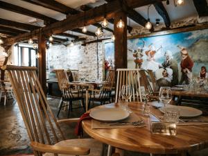 jadalnia ze stołami i krzesłami oraz obrazem na ścianie w obiekcie Atelier Boutique Hotel w Szkodrze