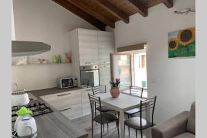 - une cuisine et une salle à manger avec une table et des chaises dans l'établissement Casetta al Portico, relax e tranquillità, à Porlezza