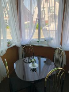 einen Tisch und Stühle vor einem Fenster in der Unterkunft Pension „La Rose“ in Norden