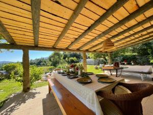 a wooden pergola with a table on a patio at Casa de Vilar de Rei, a tranquilidade do mundo rural in Ponte de Lima