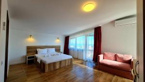 a hotel room with a bed and a couch at Elina2 in Techirghiol