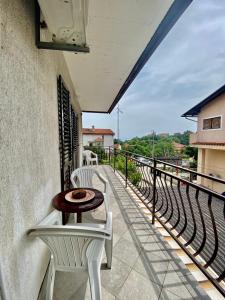a balcony with two white chairs and a table at Apartman Mira in Opatija