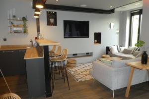 a kitchen and living room with a bar and a couch at villa avec piscine 29°, Jacuzzi 35° et billard in Martignas-sur-Jalle