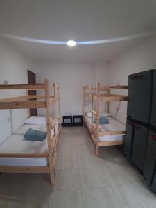a room with three bunk beds and a refrigerator at Albergue La Costana in Oviedo