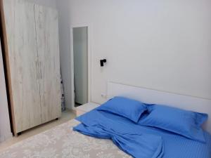 uma cama com almofadas azuis num quarto em Stella Marina Family Apartment 2 em Dhërmi