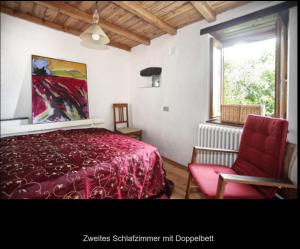 1 dormitorio con cama roja y silla roja en Casa Costa - Ruhe und Natur pur, en Carpasio