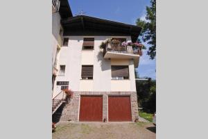 Casa blanca con balcón con puertas rojas en Casetta Anita en Cavalese