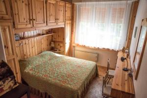 a bedroom with a bed and a desk and a window at Casetta Anita in Cavalese