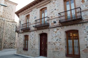 a brick building with balconies and a door at La Casa del Médico Hostería Rural in Urda