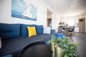 a living room with a blue couch with a yellow pillow at 1oak rentals 2 in Vir