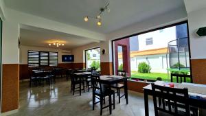 a restaurant with tables and chairs and a large window at Elina2 in Techirghiol
