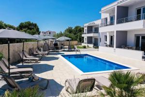 a villa with a swimming pool and lounge chairs at 1oak rentals 2 in Vir