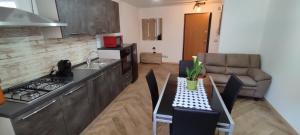 uma cozinha com uma mesa e uma cozinha com um sofá em Manuel Guesthouse Arta terme em Arta Terme